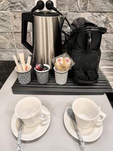 a table with two cups and utensils and a coffee pot at LOFT & SPA PRIVATIF in Dijon