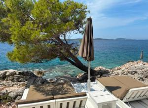 a patio with an umbrella and the ocean at Takoma Hvar in Hvar