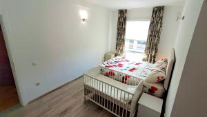 a baby crib in a room with a window at Villa Alpine in Valjiosi +39 photos