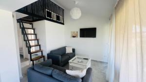 a living room with a blue couch and a staircase at Regina Maris in Betina