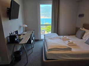 a hotel room with two beds and a desk and a window at Hotel Garni Rosmari in Brenzone sul Garda +82 photos