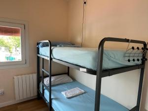 two bunk beds in a room with a window at Can Cocollona in Girona