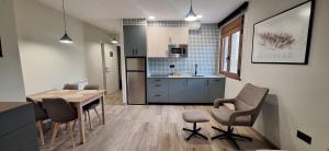 a kitchen and dining room with a table and chairs at Apartamentos Saila in Castejón de Sos
