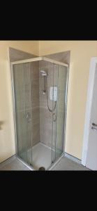 a shower with a glass door in a bathroom at The Urban Haven in Limerick +18 photos