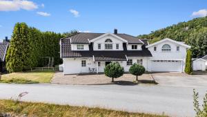 a white house with a black roof at Cozy apartment in South of Norway! in Svenevik
