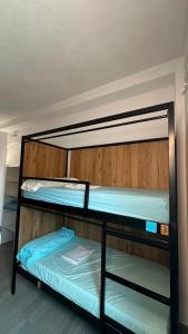 two bunk beds in a dorm room with blue sheets at Can Cocollona in Girona