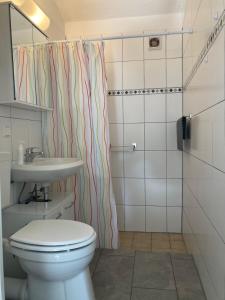a bathroom with a toilet and a sink and a shower at Gästehaus Lauerwald in Niesky +15 photos