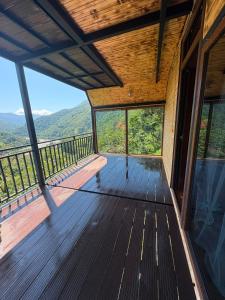 a large wooden balcony with a view of the mountains at Eco house luma in K'eda