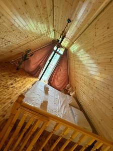 a small bed in a wooden room with a window at Eco house luma in K'eda +2 photos