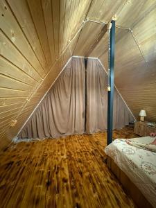 a bedroom with a bed and a wooden floor at Eco house luma in K'eda