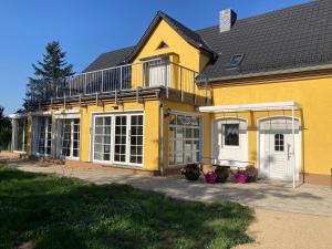 a yellow house with a balcony on top of it at Gästehaus Lauerwald in Niesky