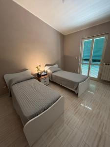 a bedroom with two beds and a table and a window at A casa di Lea2 in Gioia dei Marsi