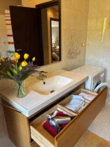 a bathroom with a sink and a vase of flowers at A casa di Lea2 in Gioia dei Marsi +6 photos