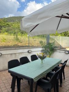 a table with chairs and an umbrella on a patio at A casa di Lea2 in Gioia dei Marsi