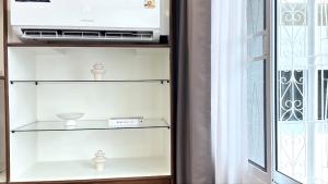 a glass shelf with a microwave and a window at April Ari-Saphankhwai in Bangkok