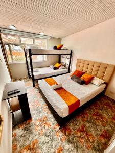 a bedroom with two bunk beds and a table at Hotel Flamante Bulevar in Bogotá