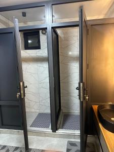 a bathroom with a shower with a glass door at Teskey Hostel Karakol in Karakol