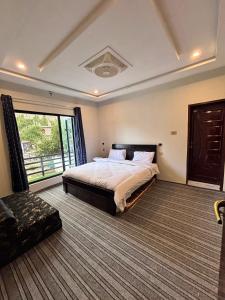 a bedroom with a large bed and a large window at Gold Star Hotel Skardu in Skardu