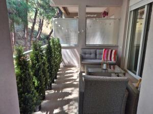 a porch with trees and a couch on a house at Sea Esta Apartment in Nea Peramos +20 photos