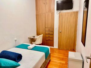 a bedroom with a bed and a tv on the wall at Hotel Flamante Bulevar in Bogotá