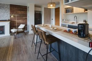 a kitchen with a counter with chairs and a stove at Private Terrace with Wellness Studio & Fireplace in Puerto Varas +20 photos