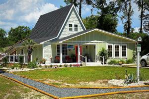 a house with a yellow hose in front of it at Sunset n Chill in Sunset Beach