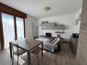 a living room with a bed and a table with chairs at Tarvisium Apartment in Treviso