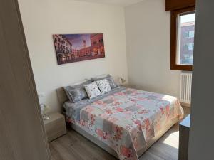 a bedroom with a bed and a picture on the wall at Tarvisium Apartment in Treviso