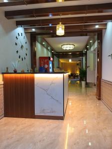 a lobby with a counter with a large clock on the wall at AYUB Modern & Heritage HOTEL in Bukhara