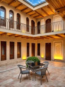 a patio with a table and chairs in a building at AYUB Modern & Heritage HOTEL in Bukhara