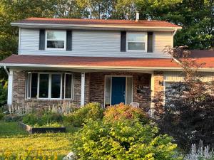 a brick house with a blue door in a yard at Sunset Suite in Bridgewater