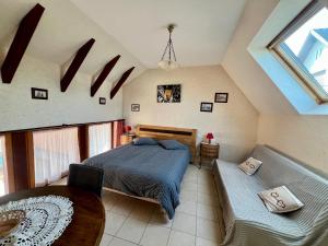a bedroom with a bed and a couch at Mélodies d'Alsace in Lipsheim