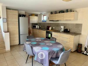 a kitchen with a table and chairs in a room at Mélodies d'Alsace in Lipsheim