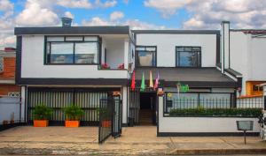 a white house with flags in front of it at Hotel Flamante Bulevar in Bogotá