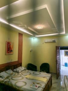 a bedroom with a large bed in a room with chairs at Résidence BEDEL in Yamoussoukro