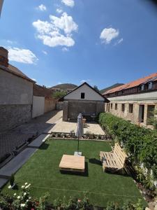 a patio with two chairs and a table and an umbrella at Happyzem in Sátoraljaújhely