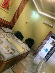 a room with a bed with chairs in it at Résidence BEDEL in Yamoussoukro