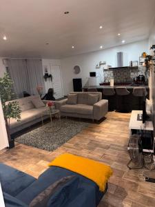 a living room with two couches and a kitchen at Le Joyau de Gournay - Proche Paris & Disneyland in Gournay-sur-Marne