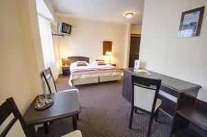 a hotel room with a bed and a table and chairs at Hotel Anek in Mrągowo +47 photos