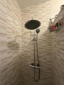 a shower with a shower head in a bathroom at Appartement entier accès rapide Paris et parc dexpo in Sevran