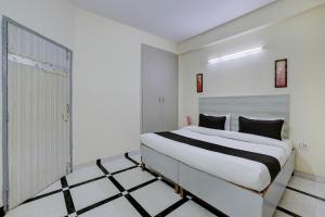 a bedroom with a large white bed in a room at Hotel O DLF Phase 1 Metro Station Gurugram in Gurgaon