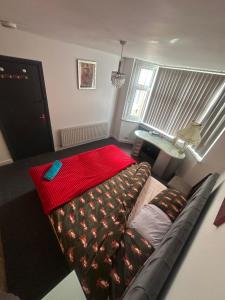 a living room with a couch and a red blanket at Quiet room Nr2 in Coundon