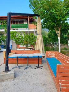 a table and a chair and a umbrella and a table at Denaj House in Himare