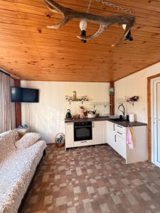 a kitchen with white cabinets and a wooden ceiling at Вила Чочита in Trapeskovtsi
