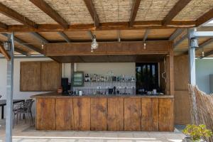 a large wooden bar in a patio with a table at Marion Apartments in Kourouta