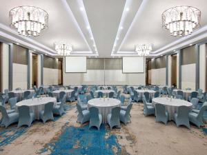 a conference room with tables and chairs and chandeliers at Mercure Serpong Alam Sutera in Serpong +122 photos