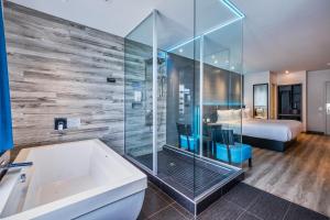 a bathroom with a tub and a bedroom with a bed at Hôtel Ô Laval in Laval