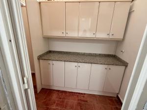 a kitchen with white cabinets and a tile floor at Villa Nasra in Los Altos +3 photos