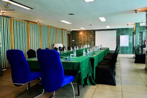 a conference room with green tables and blue chairs at Hotel Résidence La Falaise in Douala