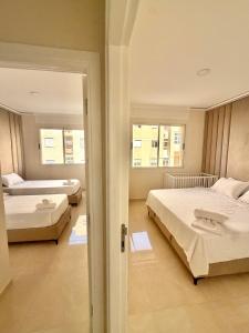 a bedroom with two beds and a hallway with two windows at Al Hoceima Luxury Residence Amina 3 in Al Hoceïma